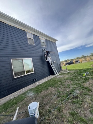 Professional house exterior painting in Bozeman MT - Big Sky Painting residential project with ladder and safety equipment