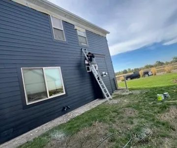 Professional house exterior painting in Bozeman MT - Big Sky Painting residential project with ladder and safety equipment