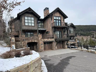 High-end mountain home exterior painting with winter landscape - Big Sky Montana luxury property